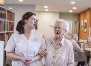Animatrice marchant en tenant le bras d'une résidente