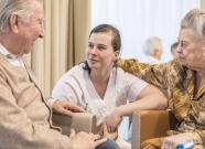 Infirmière entourée de deux personnes agées