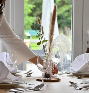 Préparation d'une table du restaurant de la résidence Augustin